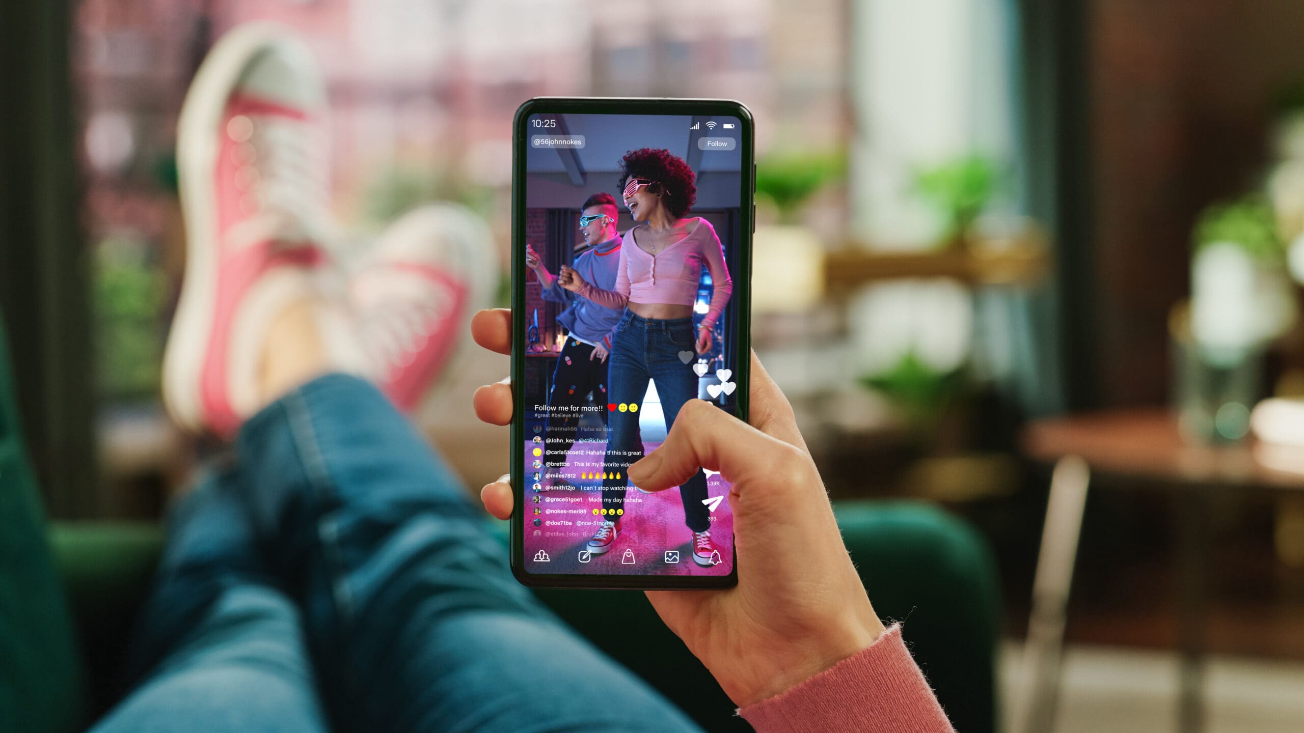 Person holding a smartphone while watching a TikTok video featuring two people dancing, representing modern social media engagement and short-form content.