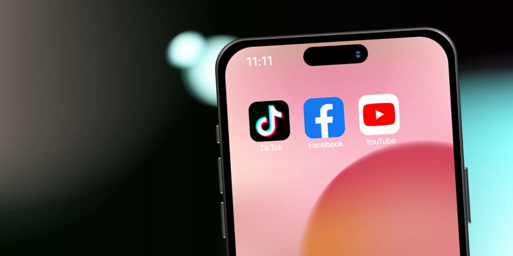 We Discover What's Next in YouTube Algorithm & Video Marketing Close-up of smartphone showing TikTok, Facebook, and YouTube app icons, highlighting short-form video competition.
