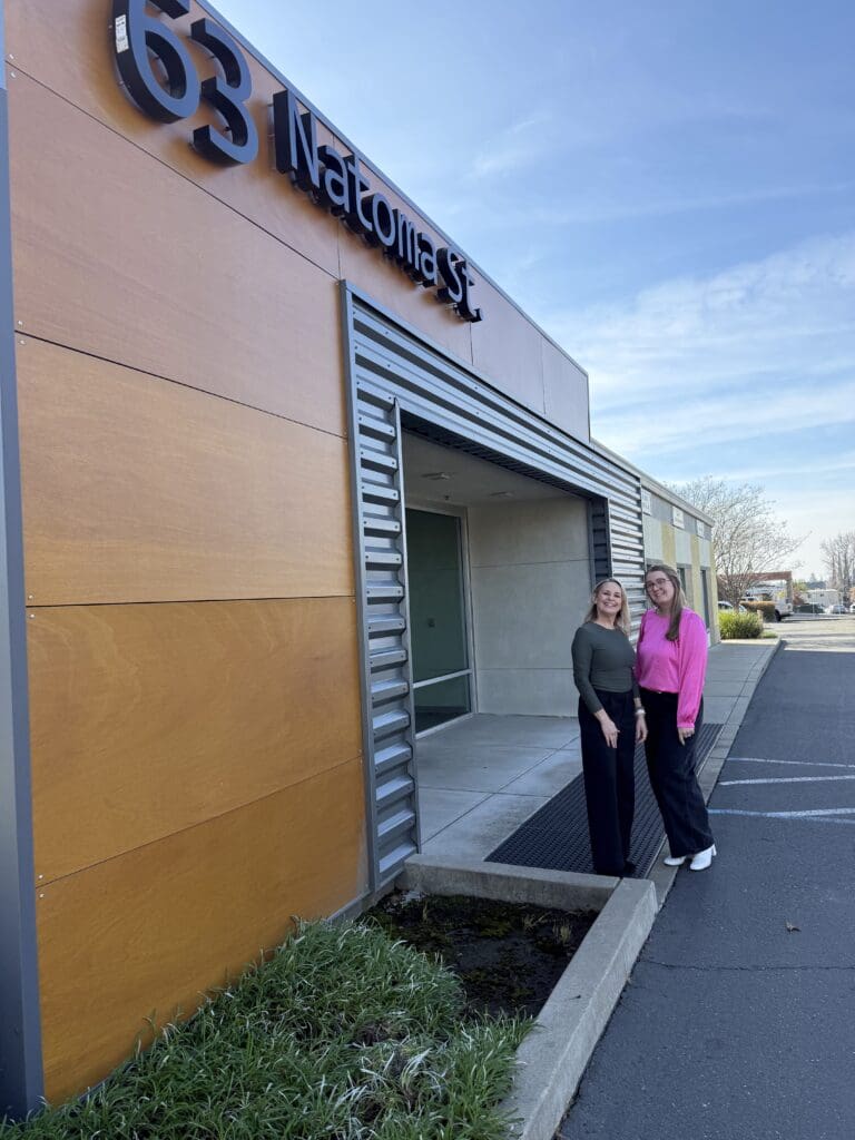 Image of Sara Espinosa and Kayla Amick standing in front of the Creative Marketing Arts office in Folsom
