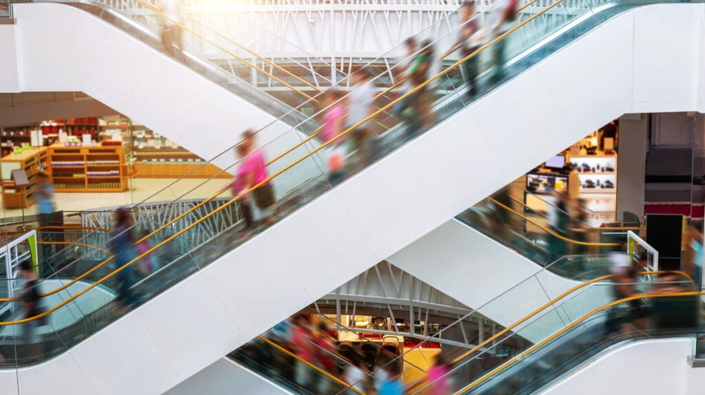Busy shopping center escalators illustrating increased foot traffic connected to Gen Z mall trends.